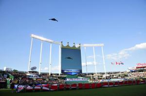 A nuclear-capable B-2 Stealth Bomber flies over a gigantic flag at the 2012 Baseball All-Star Game