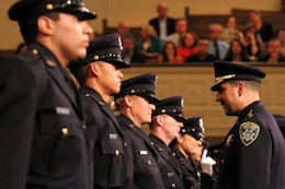 Asssistant Chief of Police Paul Figueroa, center, congratulates the graduates after they are presented with their badge during the graduation ceremony for the 167th Police Academy at the Scottish Rite Temple in Oakland, Calif., on Friday, Sept. 20, 2013. 36 cadets successfully completed the six-month course.(Laura A. Oda/Bay Area News Group)