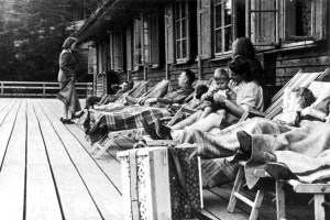SS officers relax together with women and a baby on a deck at Solahütte. As the SS members took time off, hundreds were being exterminated nearby at Auschwitz.